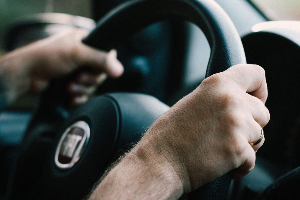 a man driving a car with his hand on the steering wheel - Hit-and-Run Victims